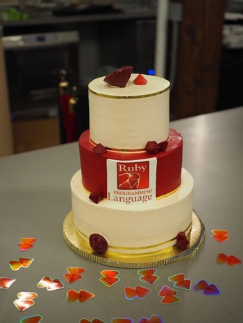 A three tier cake decorated with rubies.